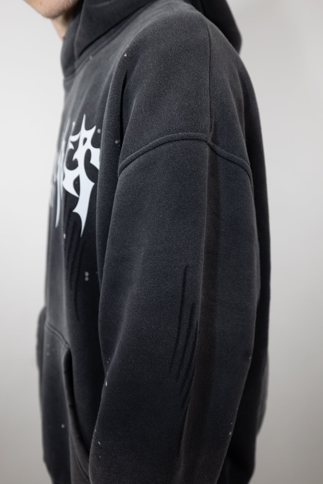 CyberWaver hoodie sleeve detail with subtle distressed markings and a minimalist cyber sigil engraving, adding to the cyberpunk and underground aesthetic